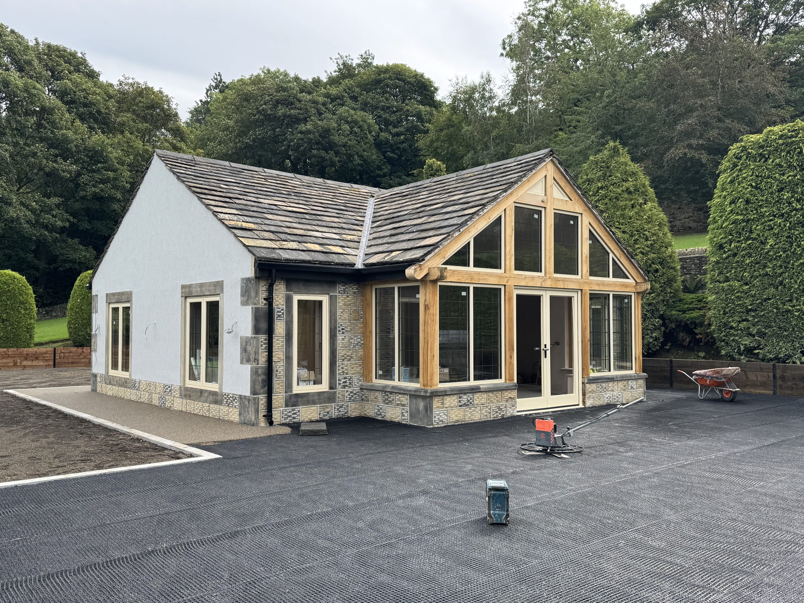 External view of a new garden room with Oak Frame, stone and render walls, timber windows and york stone roof.