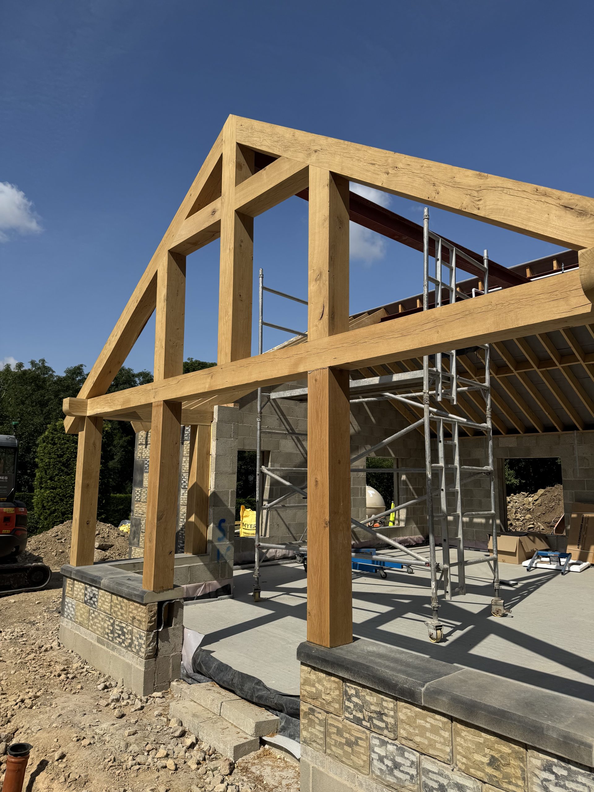 External view of a new garden room with Oak Frame, stone and render walls, timber windows and york stone roof.
